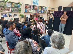Un presentador, una flor y un vendedor de globos en la biblioteca